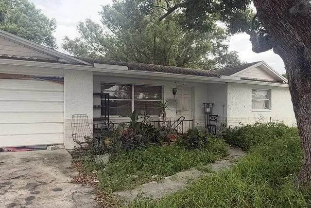 Overgrown Florida house with a tired roof